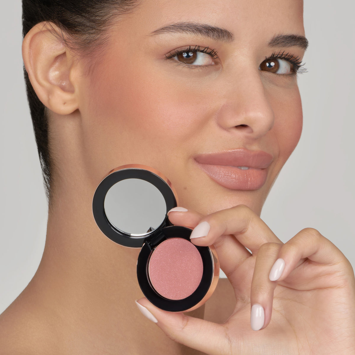 Model holding a Pippa of London blush compact